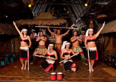 Polynesian Revue dancers in a theatrical group pose with musical instruments on the Mai-Kai stage.