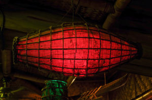 A close up of a nautical themed lantern with a warm red glow - one of many lanterns suspended from the Mai-Kai ceilings.