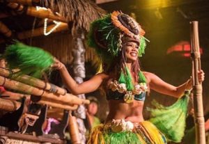 A female Polynesian dancer in a bright green costume performing on Mai-Kai’s stage.